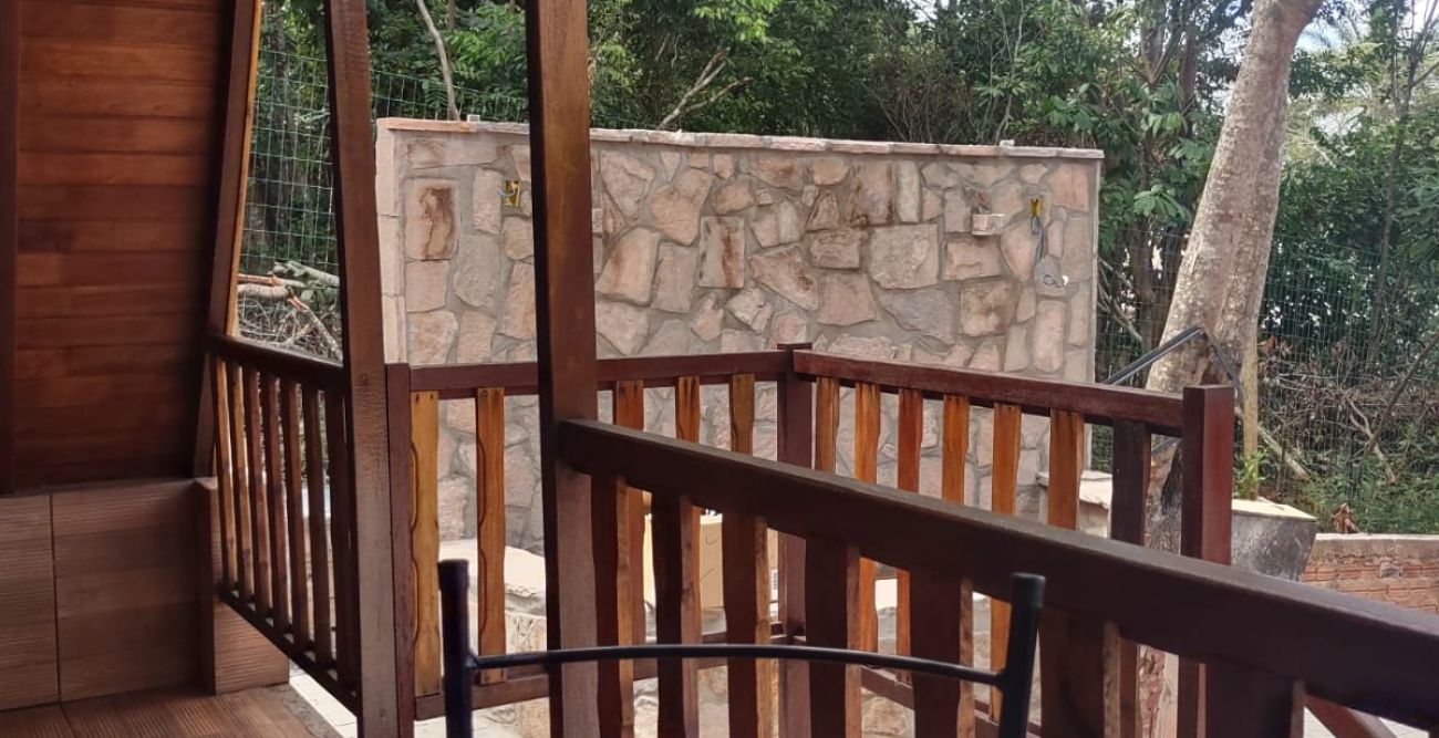 Mesa e cadeiras na varanda, de frente para o verde