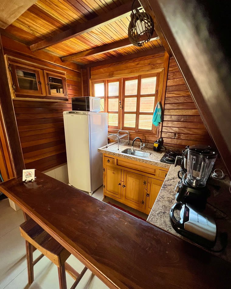 Cozinha equipada de um dos chalés, com geladeira e bancada