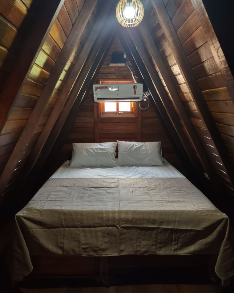 Quarto do chalé com cama arrumada
